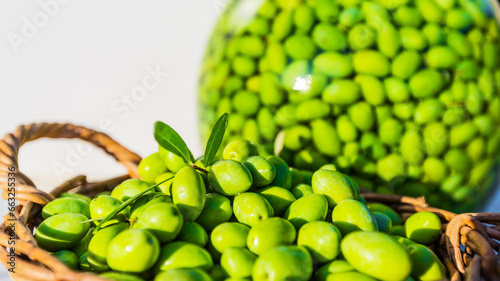 Olives vertes dans corbeille et bocal photo