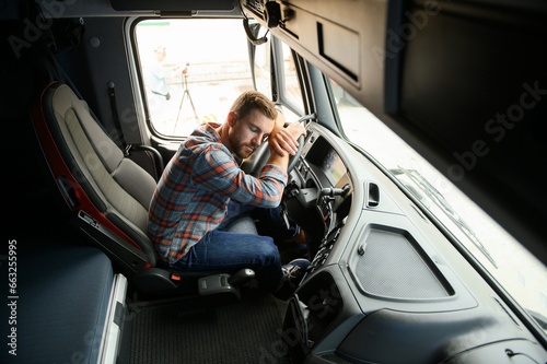 Exhausted truck driver falling asleep on steering wheel. Tiredness and sleeping concept. photo