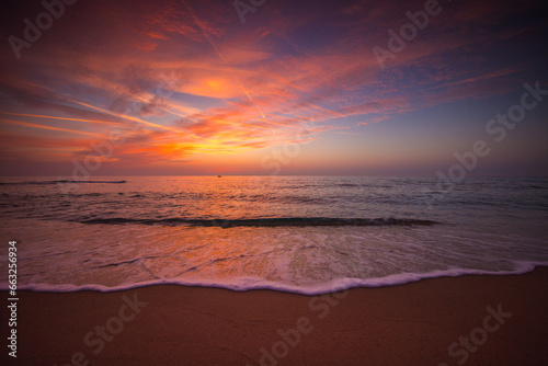Beautiful sunrise over the sea shore and beach sand