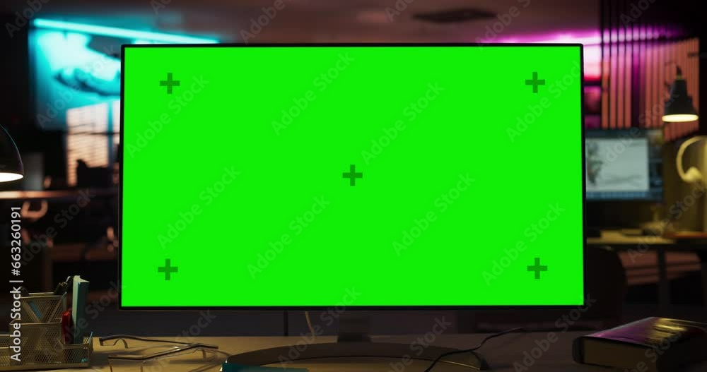 Zoom Out Shot of Desktop Computer Monitor on a Wooden Desk with a Green Screen Chromakey Mock Up Display. Office Working Station for Game Developer in Creative Agency. Template For For Advertising. Zoom Out Shot of Desktop Computer Monitor on a Wooden Desk with a Green Screen Chromakey Mock Up Display. Office Working Station for Game Developer in Creative Agency. Template For For Advertising.