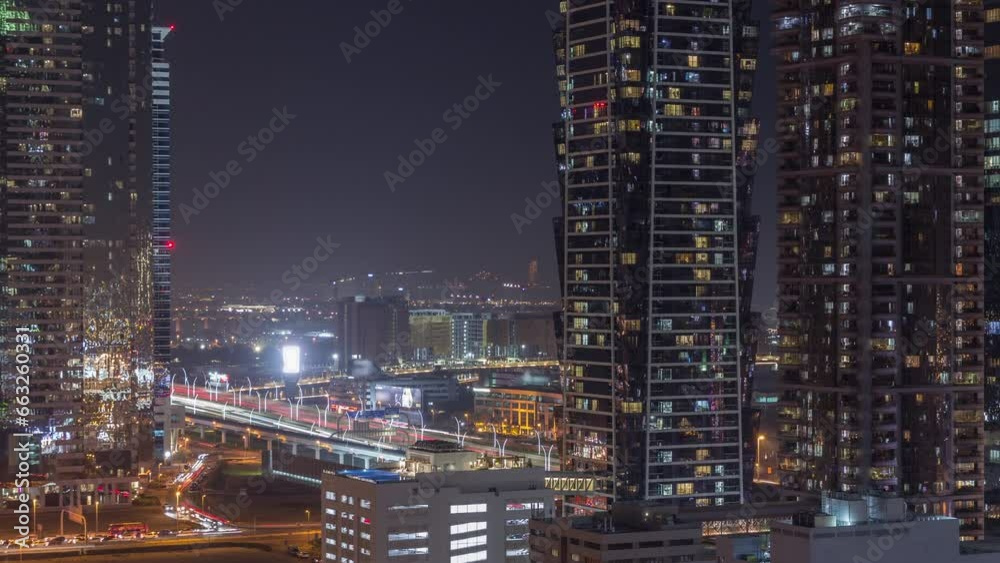 Business bay district skyline with modern architecture timelapse night from above. Aerial view of Dubai skyscrapers and illuminated towers with glowing windows near main highway. Traffic on crossroad Business bay district skyline with modern architecture timelapse night from above. Aerial view of Dubai skyscrapers and illuminated towers with glowing windows near main highway. Traffic on crossroad