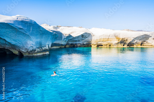 Fototapeta Naklejka Na Ścianę i Meble -  Unidentified woman swimming in azure sea near beach of Sarakiniko, Milos island, Cyclades, Greece