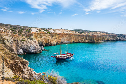 View of beautiful rocky coast near Tsigrado beach and boat on azure sea water  Milos island  Cyclades  Greece