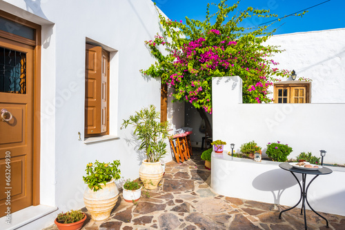 Typical Greek white house and terrace with flowers in Plaka village, Milos island, Cyclades, Greece