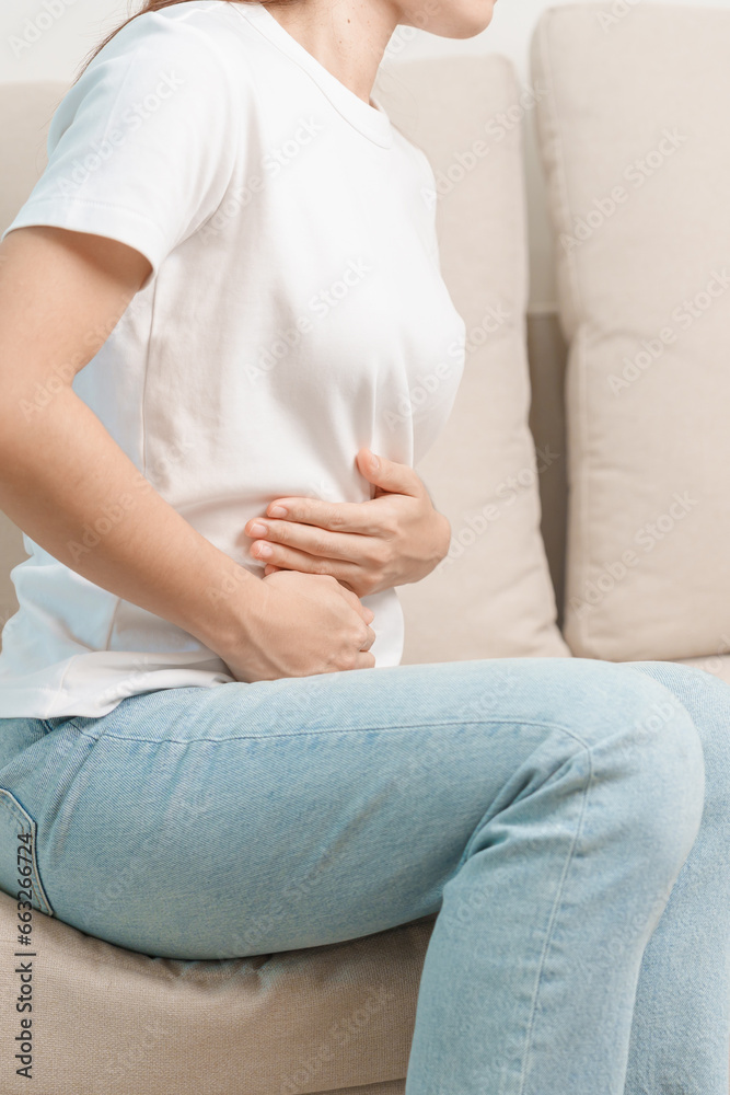 Woman having abdomen pain on the sofa at home. Liver cancer and Tumor, kidney cancer, Jaundice, Viral Hepatitis, Cirrhosis, Failure, Enlarged, Hepatic Encephalopathy, Stomach and health concept Woman having abdomen pain on the sofa at home. Liver cancer and Tumor, kidney cancer, Jaundice, Viral Hepatitis, Cirrhosis, Failure, Enlarged, Hepatic Encephalopathy, Stomach and health concept