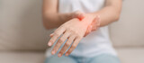 Woman having wrist pain during sitting on sofa at home, muscle ache due to De Quervain s tenosynovitis, ergonomic, Carpal Tunnel Syndrome or Office syndrome concept