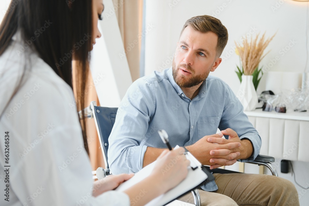 Obraz premium Young bearded man on wheelchair during home psychotherapy