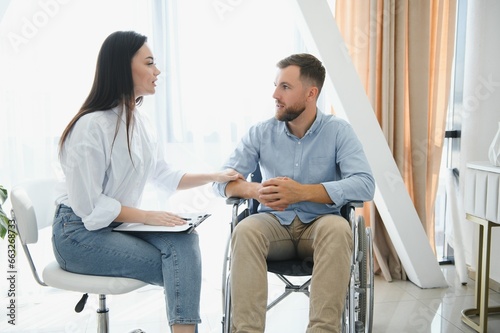 Young bearded man on wheelchair during home psychotherapy