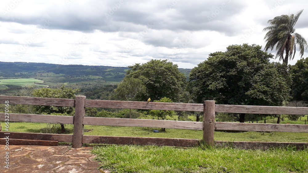 Fence in a field with birds, beautiful mountain landscape in the background. Cerca em um campo com passarinho, bela paisagem de montanhas ao fundo. Fence in a field with birds, beautiful mountain landscape in the background. Cerca em um campo com passarinho, bela paisagem de montanhas ao fundo.
