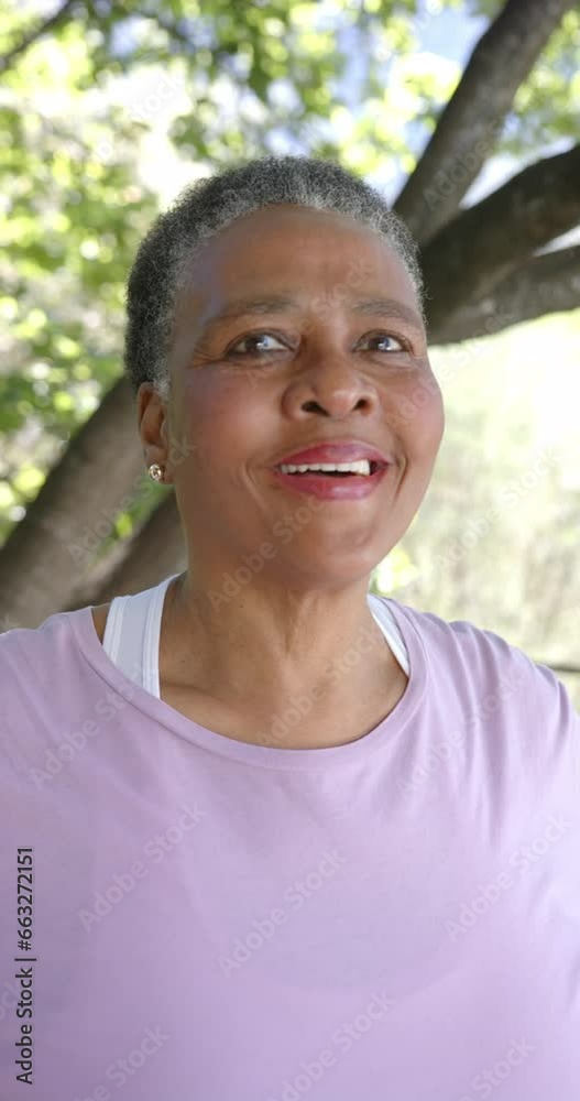 Vertical video portrait of happy senior african american woman in sunny nature, slow motion Vertical video portrait of happy senior african american woman in sunny nature, slow motion