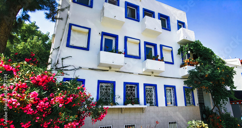 Fototapeta Naklejka Na Ścianę i Meble -  White Architecture building Exterior with flowers bougainvillea in greece style