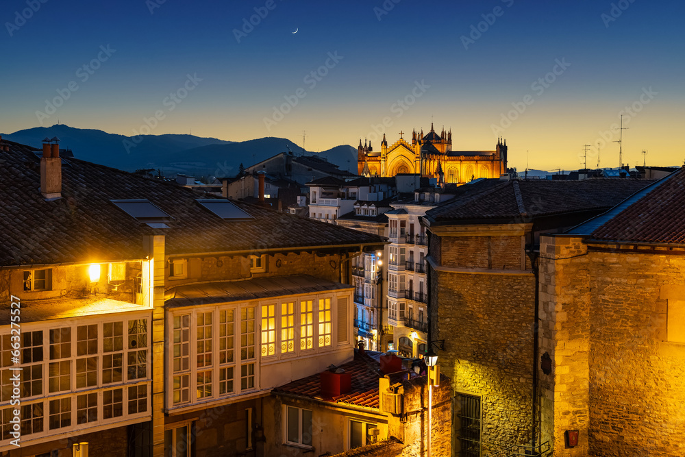 Cityscape of the city of Vitoria with the sun setting among the mountains surrounding the city, Spain.