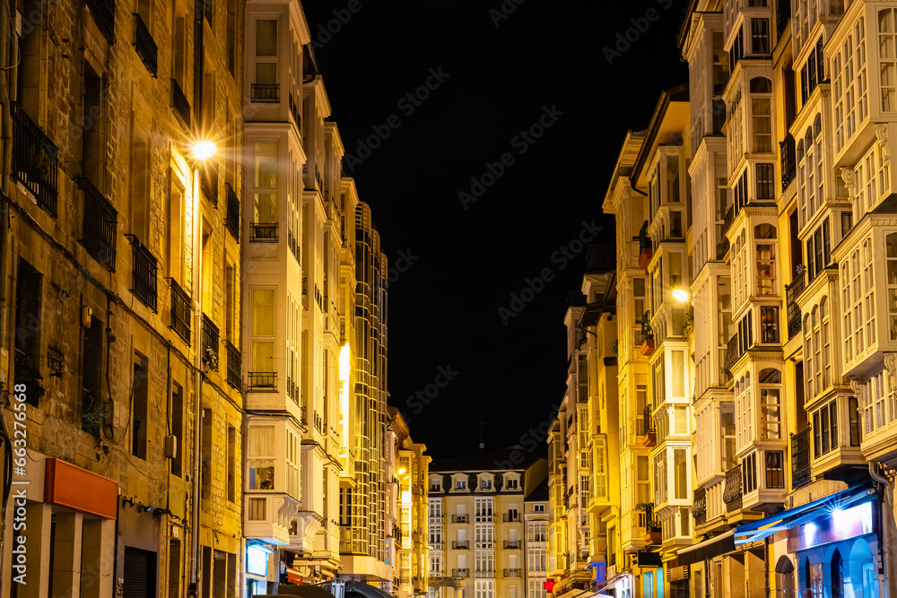 Facades of houses illuminated at night in the old town of the city of Vitoria, Spain.