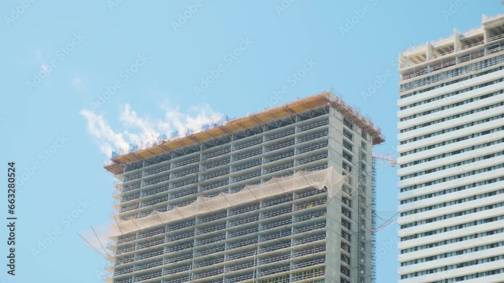 Smoke on the roof of multi storey buildings on city construction site. Building skyscraper houses, industrial development, construction site engineering Smoke on the roof of multi storey buildings on city construction site. Building skyscraper houses, industrial development, construction site engineering
