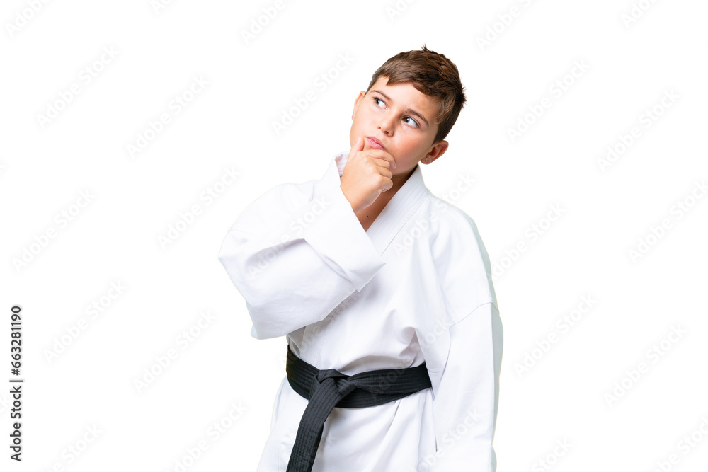 Little caucasian kid doing karate over isolated chroma key background having doubts Little caucasian kid doing karate over isolated chroma key background having doubts