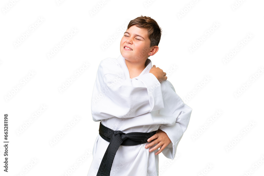 Little caucasian kid doing karate over isolated chroma key background suffering from pain in shoulder for having made an effort Little caucasian kid doing karate over isolated chroma key background suffering from pain in shoulder for having made an effort