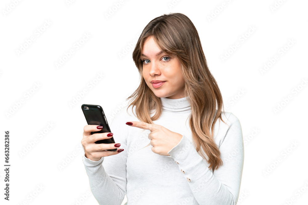 Young girl over isolated chroma key background using mobile phone and pointing it Young girl over isolated chroma key background using mobile phone and pointing it