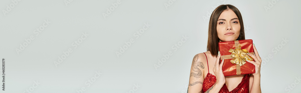dreamy beautiful woman holding red present and looking at camera, holiday gifts concept, banner dreamy beautiful woman holding red present and looking at camera, holiday gifts concept, banner