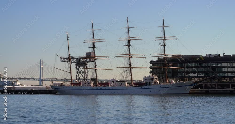 A view of Yokohama harbor with white sailboats at anchor. A view of Yokohama harbor with white sailboats at anchor.