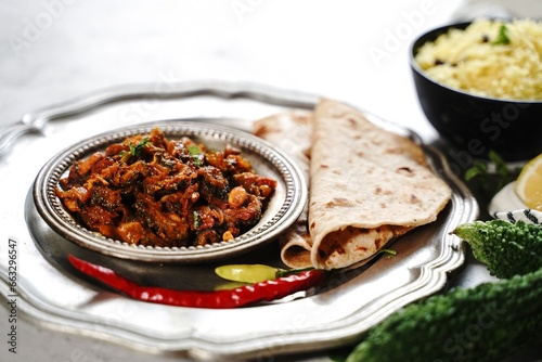 Bitter gourd curry - karela subji served with rice and roti, selective focus photo