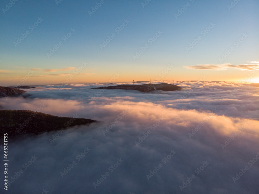 Aerial View Above Clouds of Mountain Range at Sunrise, Peeshti mountain peak in winter, Valevtsi, Gabrovo, Bulgaria. Aerial View Above Clouds of Mountain Range at Sunrise, Peeshti mountain peak in winter, Valevtsi, Gabrovo, Bulgaria.