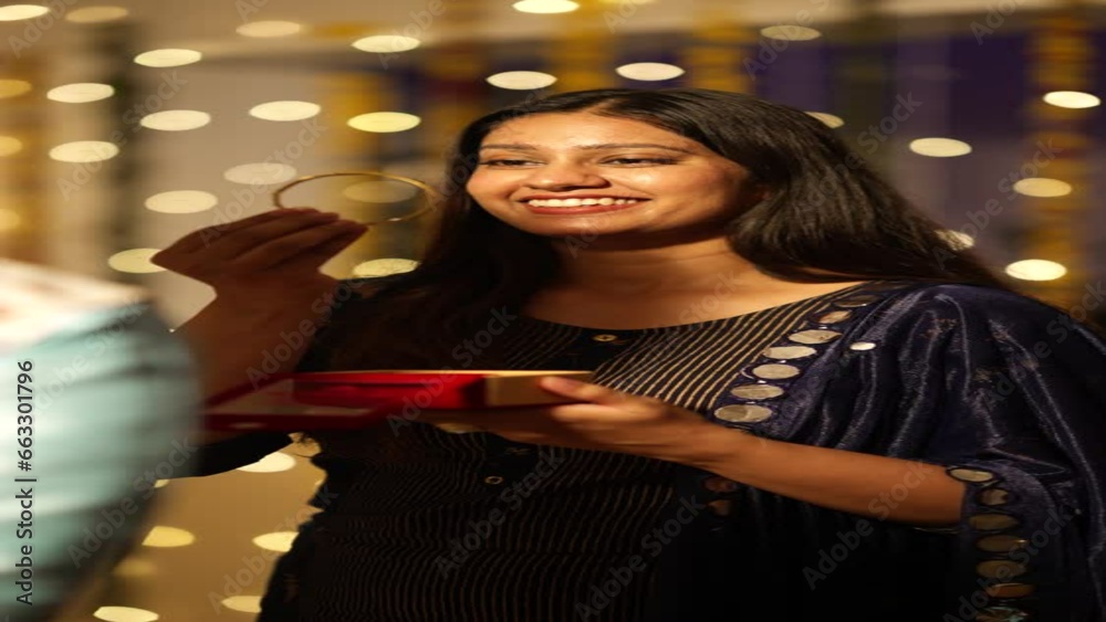 Handsome Indian man gifting gold bangles to his beautiful wife on the