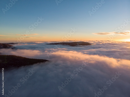 Aerial View Above Clouds of Mountain Range at Sunrise, Peeshti mountain peak in winter, Valevtsi, Gabrovo, Bulgaria. photo