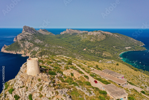 Aerial view of the Albercutx Watchtower fortress next to the Ruïnes d'en Colomer with mountain cliffs and ocean views in Balearic Islands, Spain. photo
