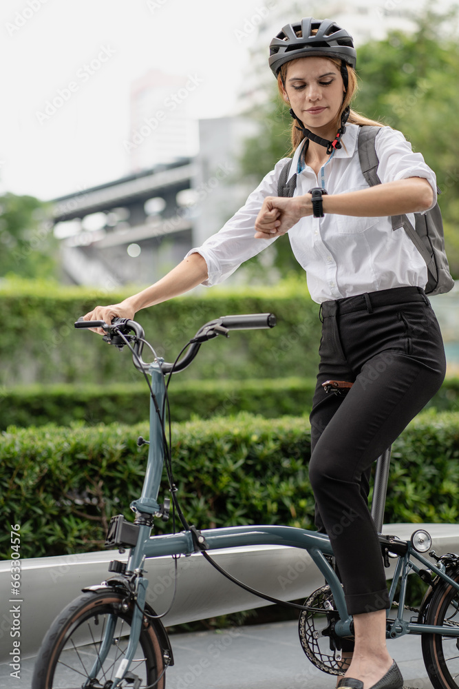 Obraz premium Eco friendly, businesswoman ride bicycle in urban to reduce carbon footprint. Beautiful woman environment preservation person commuting with bicycling. Cycling, alternative transport for clean energy.