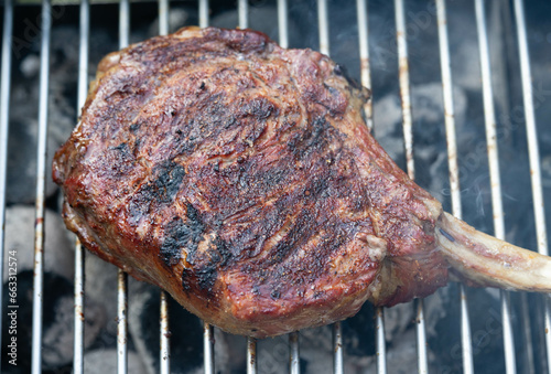 Frisches Tomahawk Steak mit Kräutern und Gewürzen photo