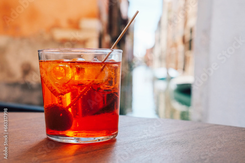 A glass of refreshing Aperol Spritz cocktail served on the deck bar in Venice. Traditional italian aperitif drink. Copy space for text. © Iryna