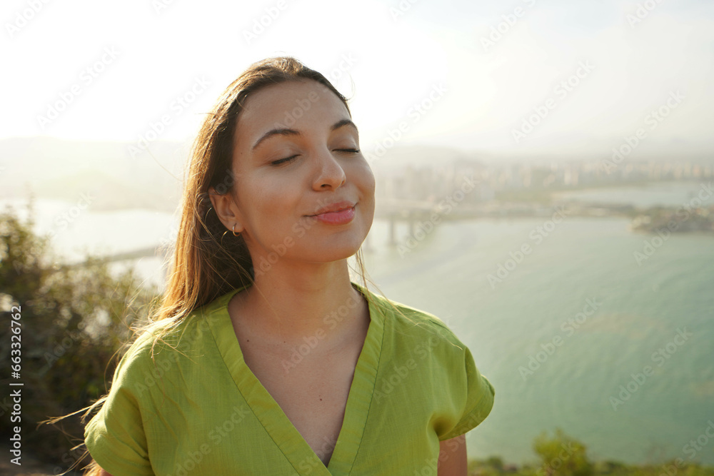 Happy traveler woman enjoying relaxed wind on face at sunset in her vacation in Brazil. Powerful and peaceful female aware of her potential concept. Happy traveler woman enjoying relaxed wind on face at sunset in her vacation in Brazil. Powerful and peaceful female aware of her potential concept.