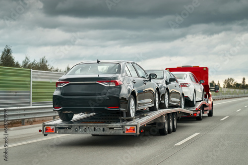 Tow truck with a cars on the highway road. Tow truck transporting car on the autobahn. Car service transportation concept. Roadside Rescue.