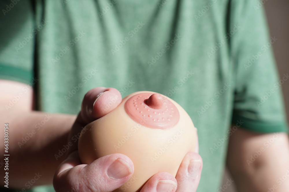hand squeezing or groping boob shaped anti-stress ball - obrazy, fototapety, plakaty 