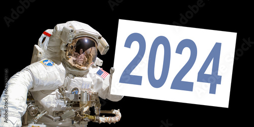 Astronaut in space holding a 2024 white  board - elements of this image are provided by NASA photo