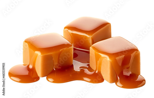 Three sweet caramel candy cubes topped with caramel sauce on white background photo