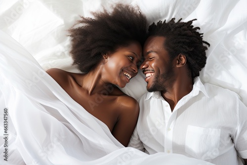 lovely afro american couple on bed peacefully sleeping looking at each other and smiling photo