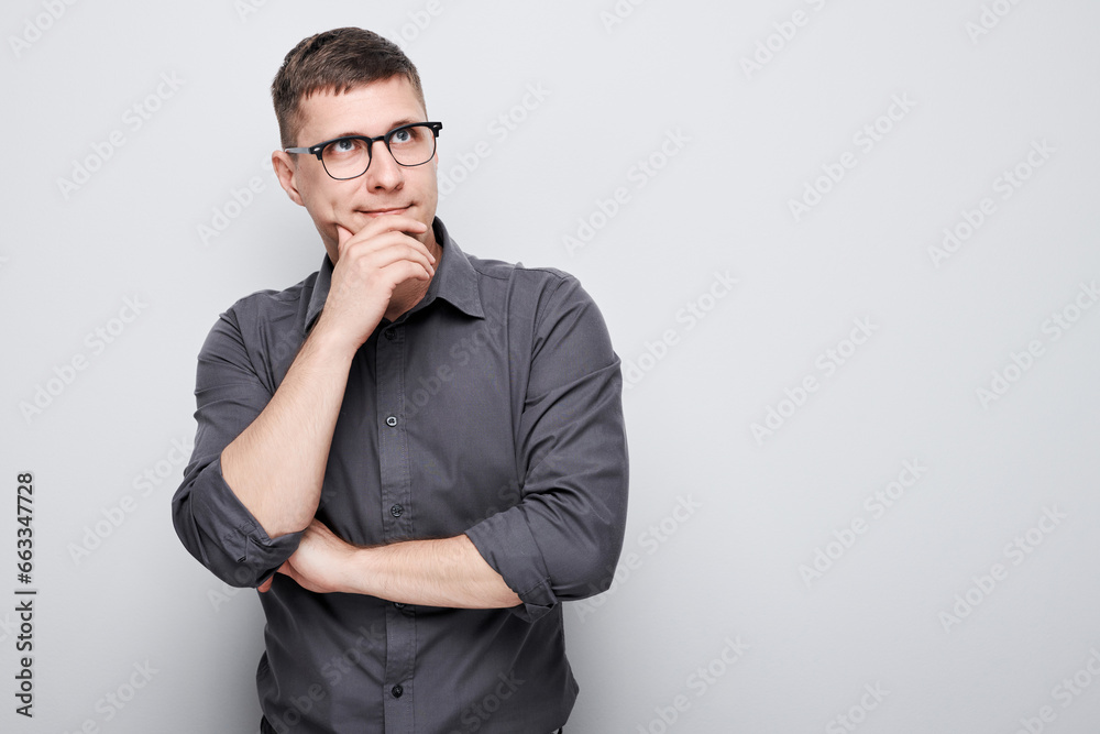 Portrait of clever man in shirt touching chin thinks doubts chooses isolated on white studio background with copy space Portrait of clever man in shirt touching chin thinks doubts chooses isolated on white studio background with copy space