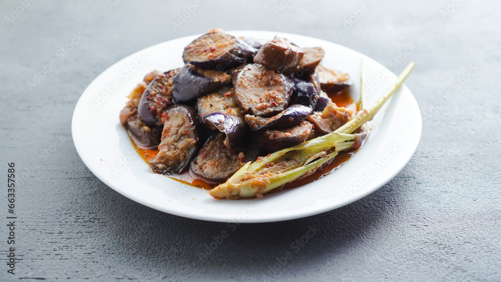 (Terong Balado) Balado eggplant served on a white plate. Single object. Table tops.