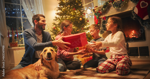 Happy Little Family Exchanging Gifts on Christmas Eve: Brother and Sister Receiving their Gifts. Happy Children Getting New Toys from Mom and Dad, with Family Dog Sharing the Moment
