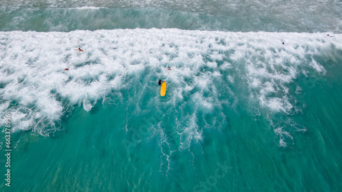 Photography Aerial view of surfer holding surfboard waiting for sea waves on Kata Beach