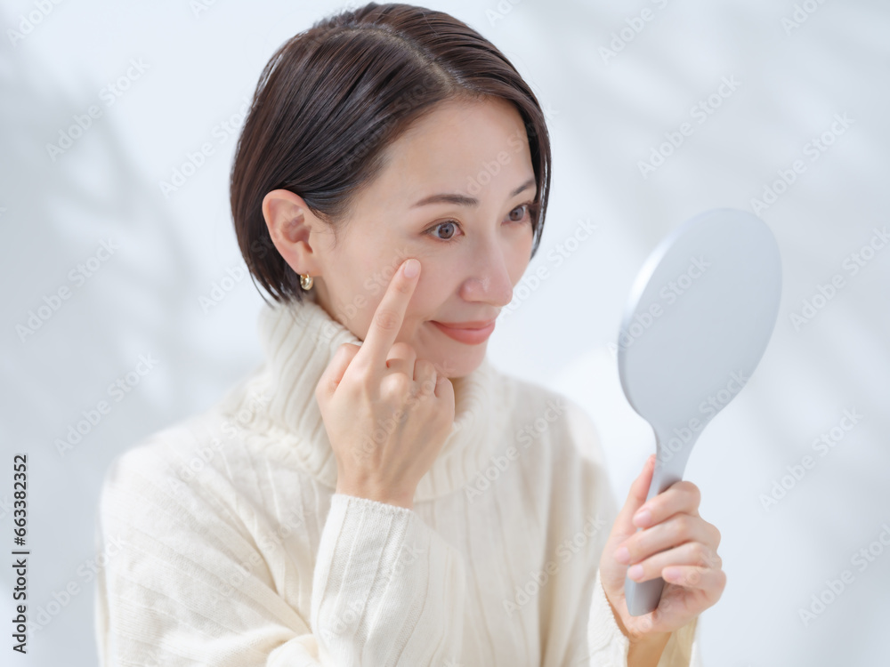 目元をチェックする女性・美容・スキンケア 目元をチェックする女性・美容・スキンケア