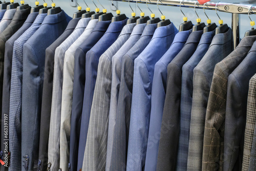 Racks with different men's suits in a men's clothing boutique.