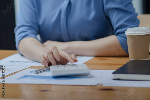 businesswoman hands working on calculator sitting at desk in office, 