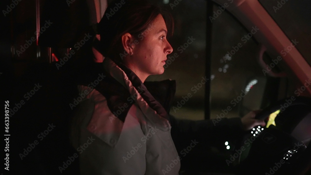 Woman driving moving truck at night. Female driver paying attention to highway road in evening journey - obrazy, fototapety, plakaty 