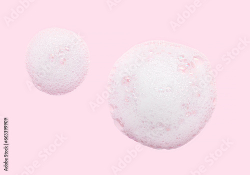 Skincare cleanser foam texture with bubbles isolated on pastel pink background. Soap shampoo face wash cleansing musse product sample photo