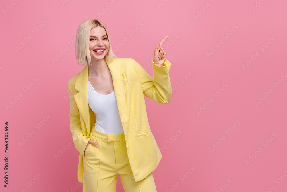 Photo of cheerful positive lady wear yellow jacket suit pointing finger empty space isolated pink color background Photo of cheerful positive lady wear yellow jacket suit pointing finger empty space isolated pink color background
