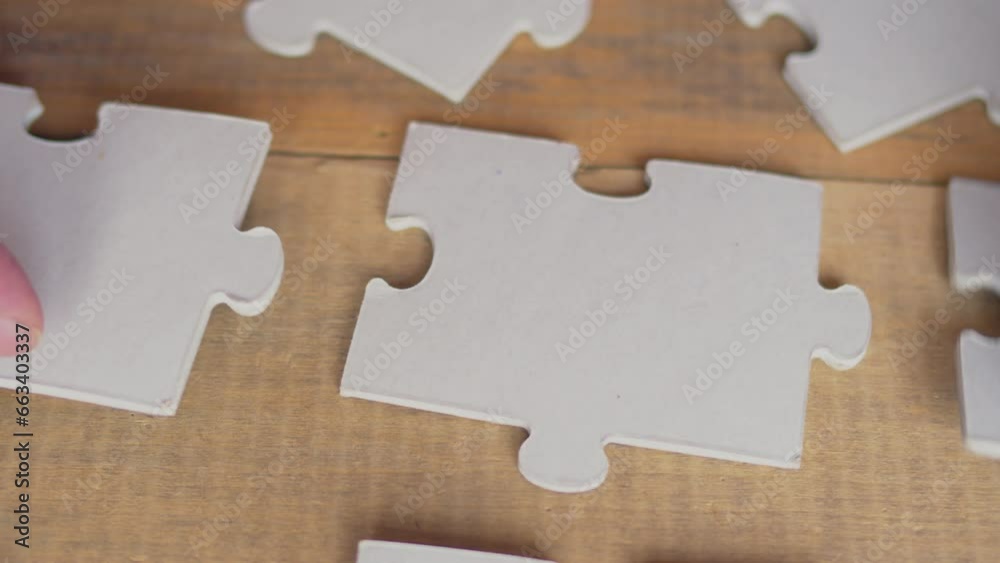 Close up view of businessman hands trying to connect assembling jigsaw