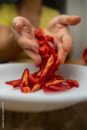 female hands holding sliced ​​red pepper in hands