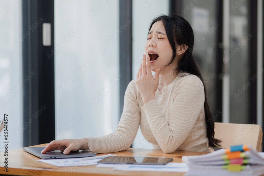 Asian businesswoman stressed and tired from work sitting in office desk, Unhappy woman feeling stressed. Asian businesswoman stressed and tired from work sitting in office desk, Unhappy woman feeling stressed.